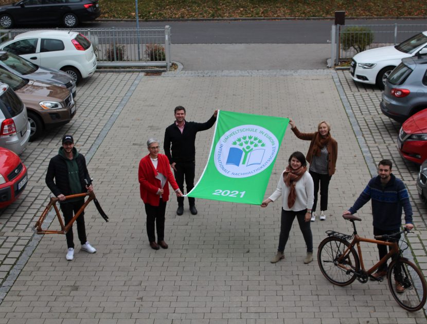 Lehrer mit Umweltschulen Logo als Fahne